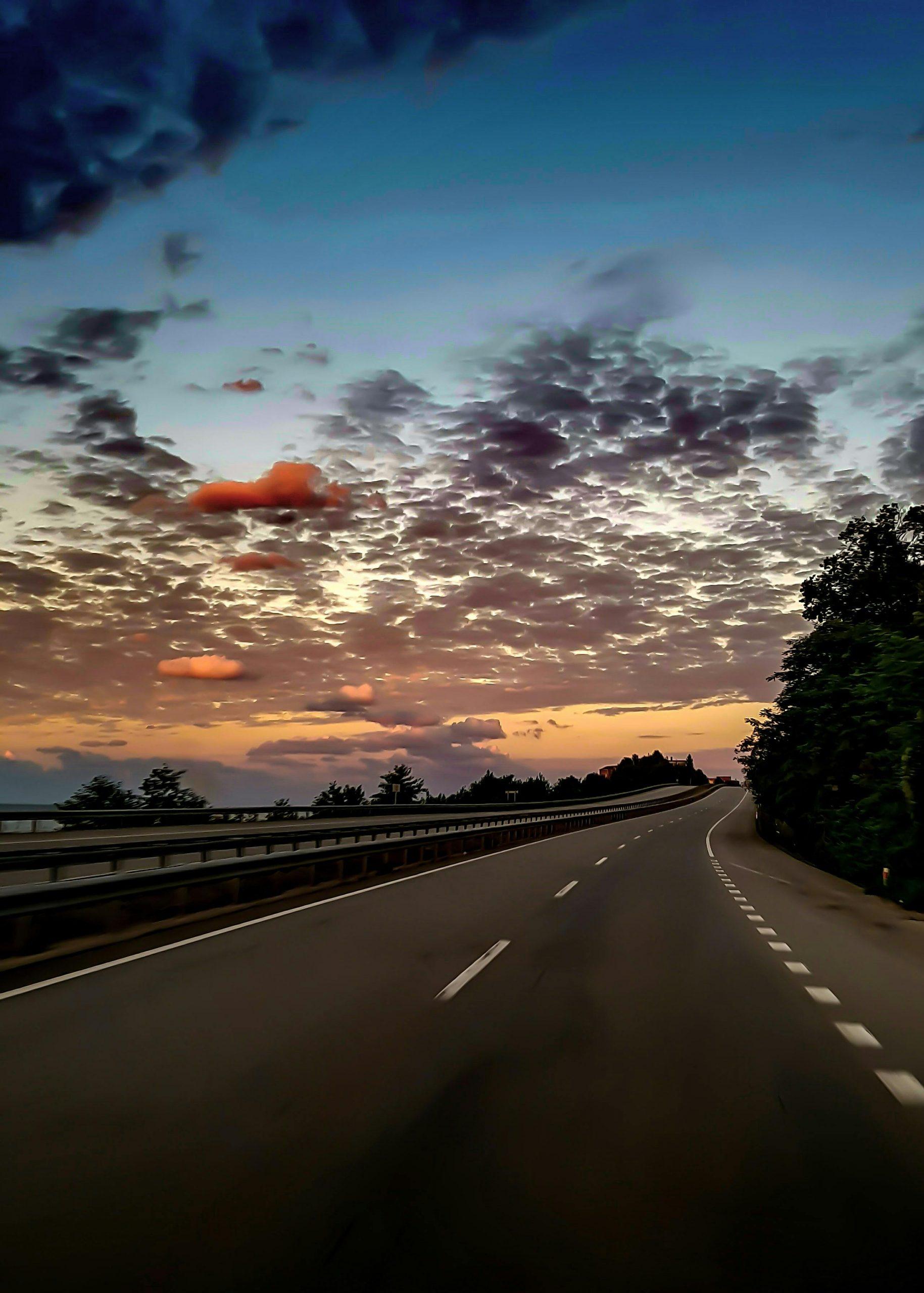 Serene highway scene with a stunning sunset sky, perfect for travel themes.